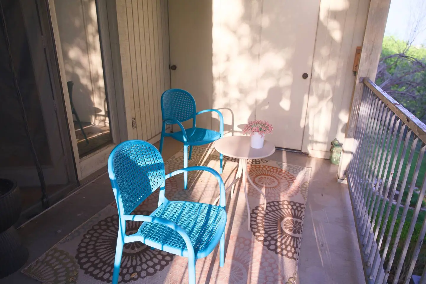 Balcony with two blue chairs and a small table