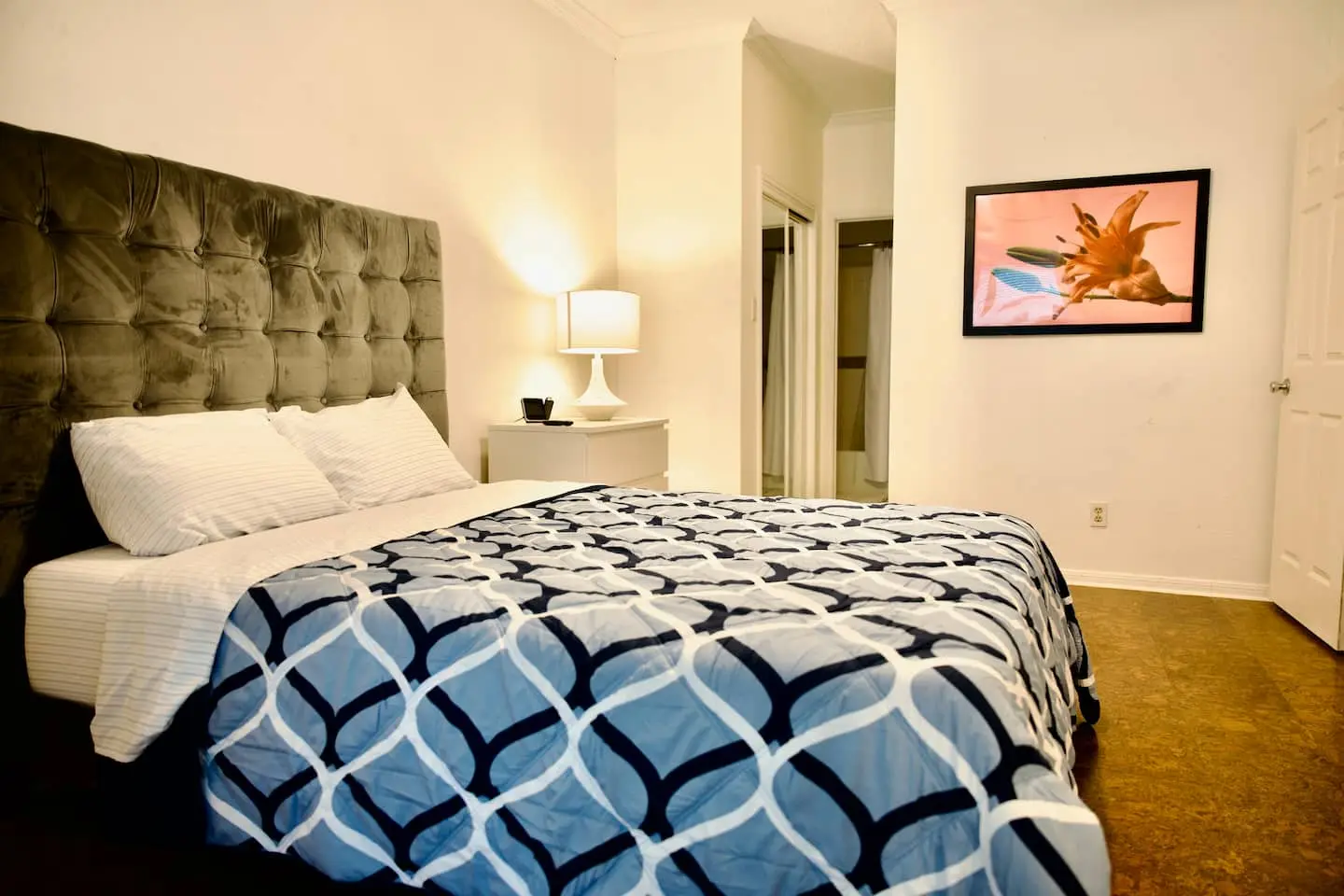 Primary bedroom with queen bed and tufted headboard